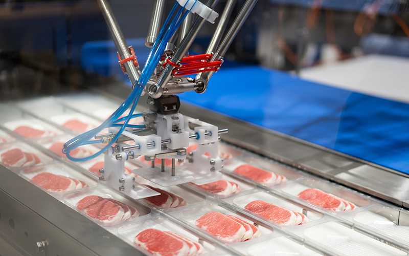 Werbegrafik zeigt den Verpackungsprozess von Fleischportionen mittels Roboterarm